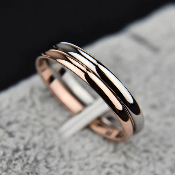 Elegant rose gold-plated titanium steel couple ring by SobPai displayed on a soft velvet cushion.