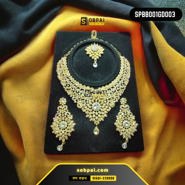 Antique gold necklace set with diamond-like white stones, matching earrings, and tikka.