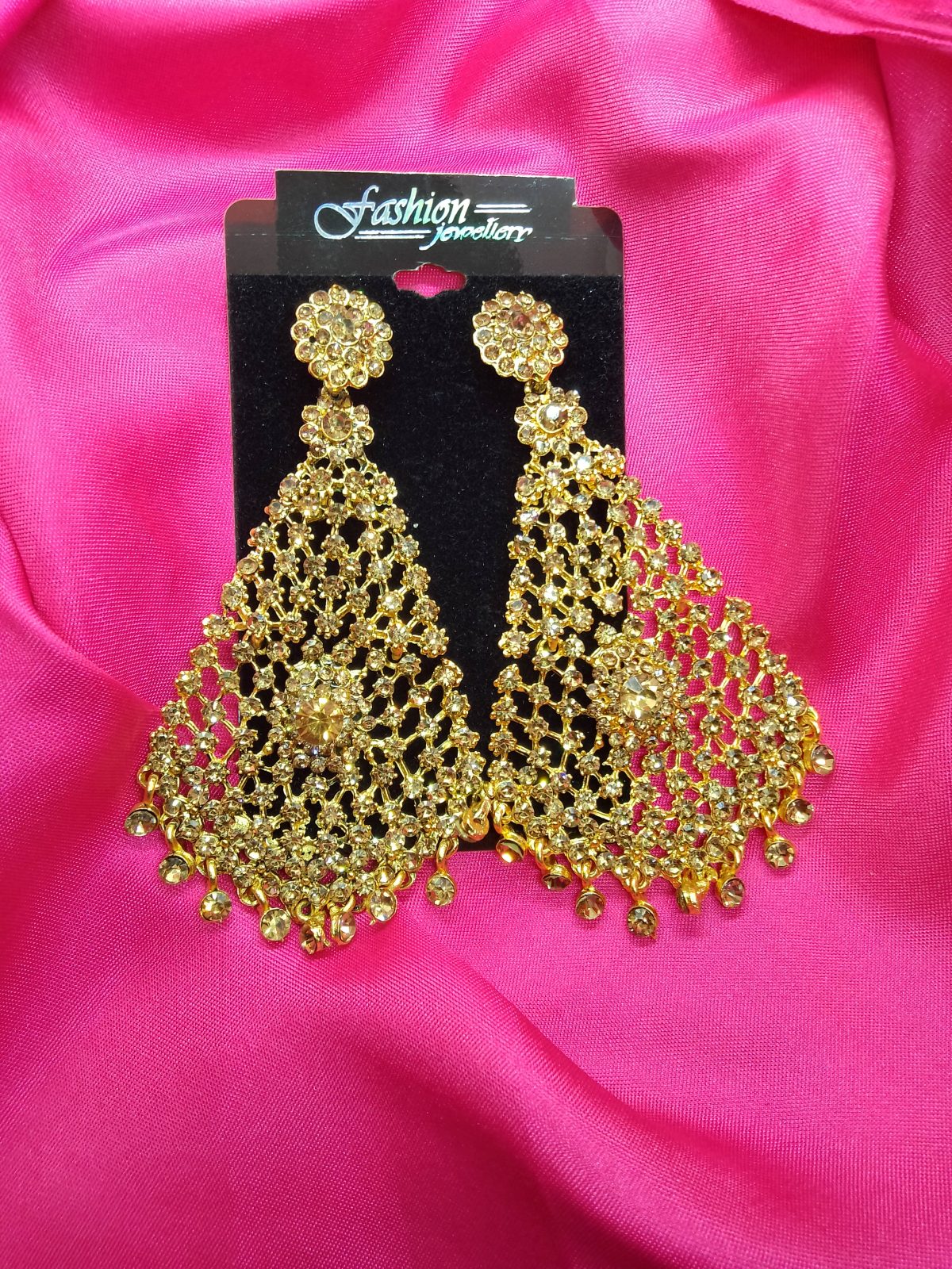 Elegant earrings showcasing intricate gold stone detailing and tassel drop style.